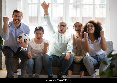 Heureux les jeunes mixed race football fans cheering équipe favorite. Banque D'Images