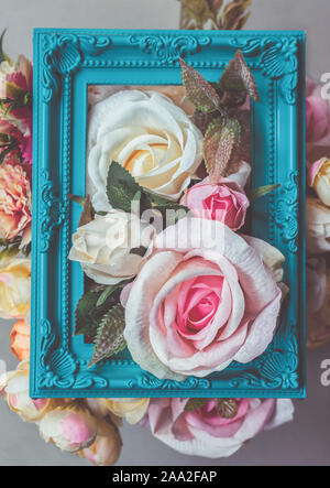 Composition faite de cadre photo et fleurs artificielles dans des tons pastel Banque D'Images