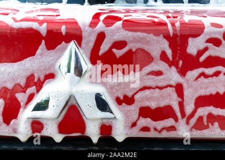 Cherkasy, Ukraine - 09.16.2018 logo Mitsubishi Motors sur la voiture rouge en mousse de savon. procédé de lavage de voiture Banque D'Images