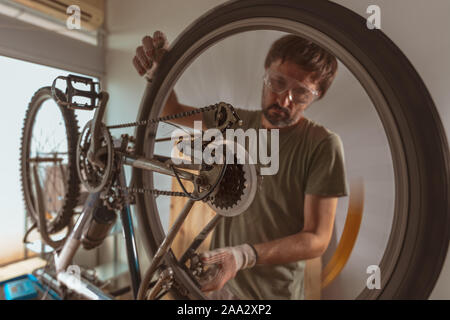 Location mechanic repairing old mountain bike en atelier, selective focus Banque D'Images