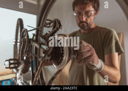 Location mechanic repairing old mountain bike en atelier, selective focus Banque D'Images
