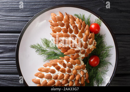 Salade festive aux amandes en forme de cônes de pin Gros plan sur une assiette sur la table. Beau menu. Haut horizontale Vue de dessus Banque D'Images