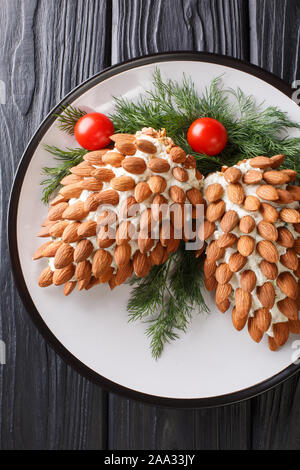 Belle salade de fromage de Noël aux amandes en forme de cônes sur une plaque sur la table. Haut Vertical Vue de dessus Banque D'Images