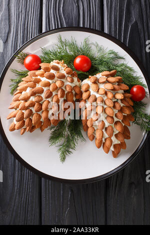 Nouvelle année, le fromage apéritif avec des amandes dans la forme de cônes de pin Gros plan sur une assiette sur la table. Haut Vertical Vue de dessus Banque D'Images