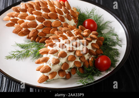 Noël nourriture savoureuse salade de fromage d'amandes sous la forme de cônes sur une plaque sur la table. servir idée horizontale. Banque D'Images