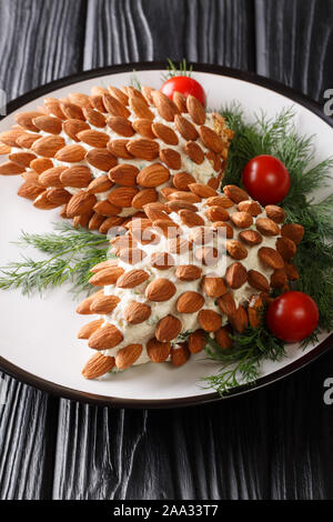 Salade de fromage apéritif de Noël aux amandes en forme de cônes sur une plaque verticale sur la table. Banque D'Images