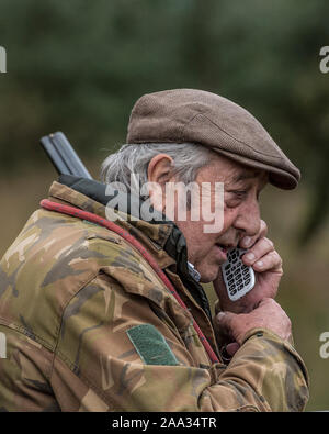 vieux chasseur utilisant le téléphone portable Banque D'Images