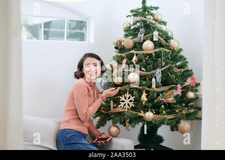 Portrait d'une jeune femme pendant les préparatifs de Noël à la maison Banque D'Images