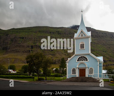 Église à Seydisfjordur bleu dans l'Est de l'Islande, montagnes en arrière-plan. Nature Paysage Banque D'Images