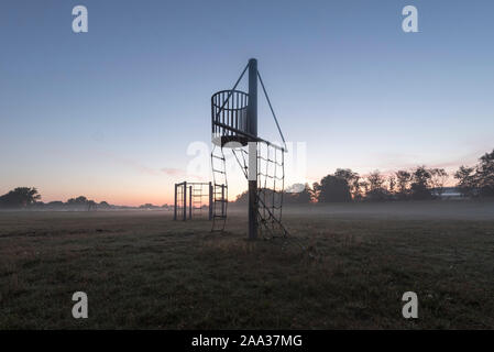 24 août 2019, l'Allemagne (allemand), Hiddensee : portiques se tenir sur une prairie de Rostock. Sur la prairie il y a un voile de brume, sur l'horizon il y a un lever du soleil. Photo : Stephan Schulz/dpa-Zentralbild/ZB Banque D'Images