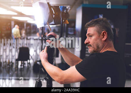 Homme d'éclairage service control suivez la lumière dans la production house Banque D'Images