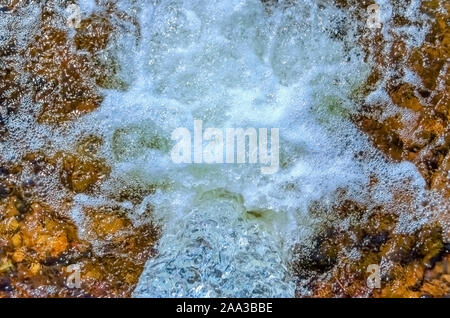 Mousse et bulles d'être créé comme l'eau s'écoule par une tempête/tuyau de drainage. Banque D'Images