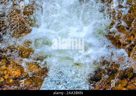 Mousse et bulles d'être créé comme l'eau s'écoule par une tempête/tuyau de drainage. Banque D'Images