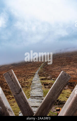 Les mourne wall menant jusqu'à la nuée couvrit Slieve Donard vue de la tourbière de Donard Banque D'Images