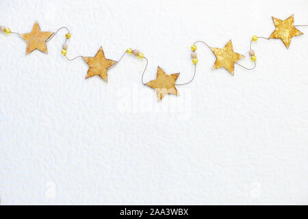 Étoiles jaunes sur une chaîne - vacances d'hiver et Nouvel An composition. Mise à plat, de haut en bas vue avec copie espace. Banque D'Images
