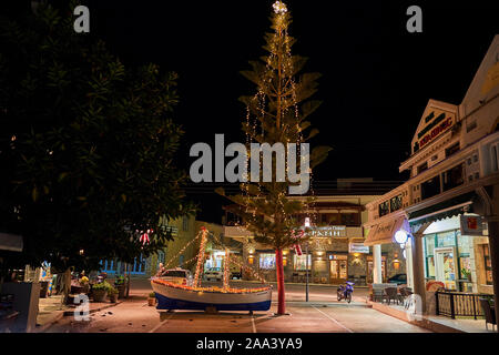 Bateau de Noël en bois décoré de nuit. Dans la tradition grecque (en particulier dans les îles), il est commun à l'ornement d'un navire au lieu d'un arbre. Banque D'Images