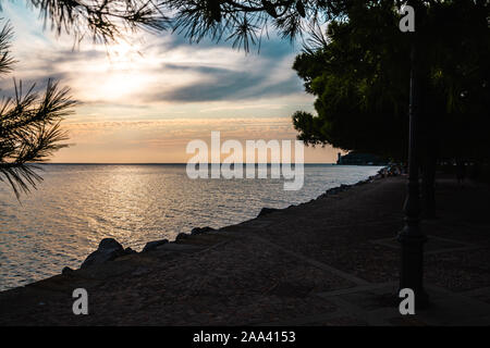 Vue spectaculaire sur la mer Méditerranée côte à Trieste en Italie alors que le coucher du soleil, avec le château de Miramare (Castello di miramare) dans l'arrière-plan. Banque D'Images