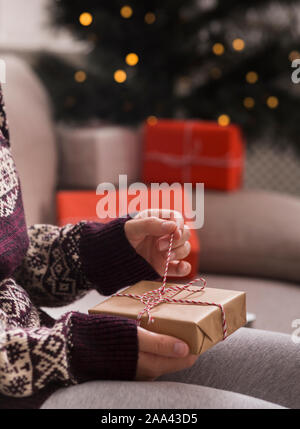 Woman unpacking Nouvelle année présente à la maison au cours de la décoration arbre Banque D'Images