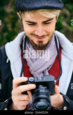 Hipster Photographe de rue l'examen de photos sur l'écran de l'appareil photo Mirrorless Banque D'Images