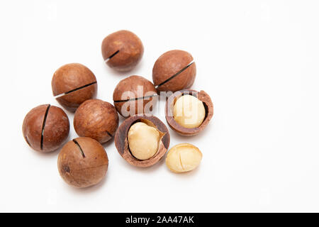 Pile de macadamia décortiquées ouvert et coquilles sur fond blanc, vue du dessus. Banque D'Images