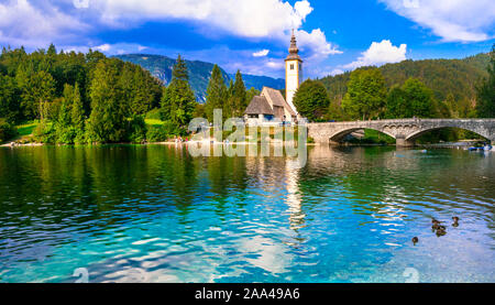 Le lac de Bohinj impressionnant,avec vue sur le vieux pont,petite église et les montagnes,Slovénie. Banque D'Images