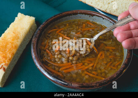 Soupe de lentilles et pain au fromage. Bol de soupe aux lentilles végétarien à la carotte, l'oignon et l'ail. Servi avec du fromage maison délicieux pain. Close up on Banque D'Images