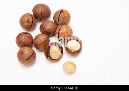 Pile de macadamia décortiquées ouvert et coquilles sur fond blanc, vue du dessus. Banque D'Images