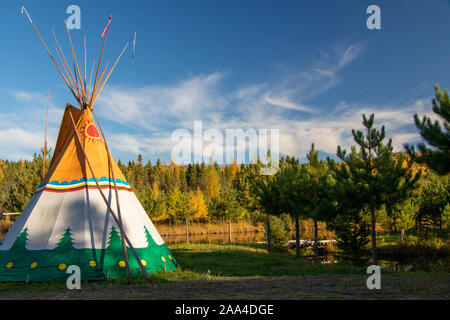 La Rivière Bostonnais (La Tuque), Québec, Canada - 11 octobre 2019 : Tipi tipi peint avec feuillage de l'automne en arrière-plan, le Domaine Notcimik, Mauricie Banque D'Images