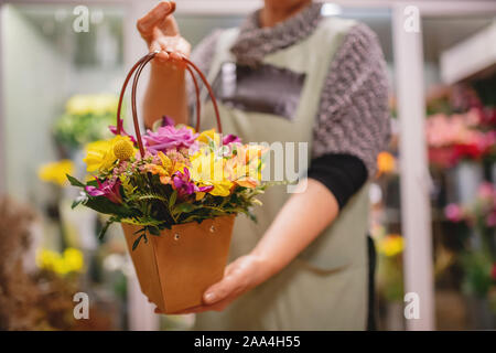 Fille fleuriste bouquet roses roses fleurs détient et chrysanthèmes jaunes en boîte cadeau. Banque D'Images