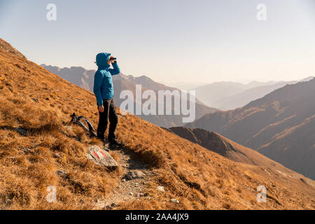 Dans les montagnes du randonneur regardant à travers des jumelles, Bad Gastein, Salzburg, Autriche Banque D'Images