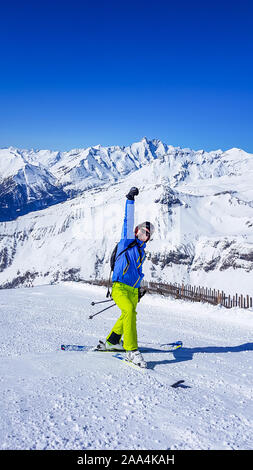 Un skieur debout sur le côté d'une pente à Heiligenblut, Autriche. Des pistes parfaitement entretenues. De hautes montagnes entourant l'homme portant un pantalon jaune Banque D'Images