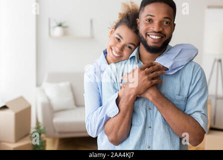 Black Couple Hugging debout dans Nouvel appartement Banque D'Images