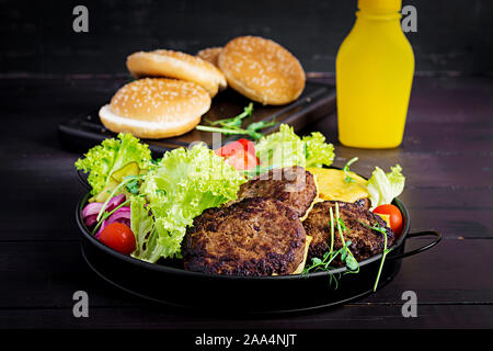 Cuisine - burger Burger de boeuf, tomates, fromage, cornichon et l'oignon rouge sur la plaque Banque D'Images