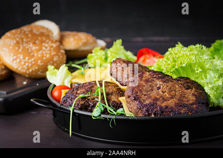 Cuisine - burger Burger de boeuf, tomates, fromage, cornichon et l'oignon rouge sur la plaque Banque D'Images