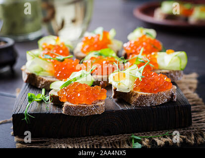 Canape avec salmon caviar rouge. Sandwich pour le déjeuner. La nourriture délicieuse. Banque D'Images