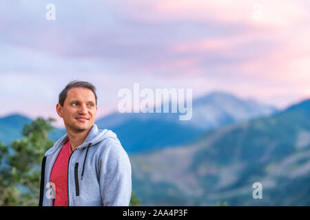 Aspen, Colorado Mountains blue violet coloré crépuscule coucher du soleil Vue d'arrière-plan flou et heureux jeune homme debout à Banque D'Images