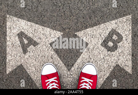 Dillema Concept. Chaussures debout sur la route d'asphalte avec deux flèches de plan A et B. Vue d'en haut. Banque D'Images