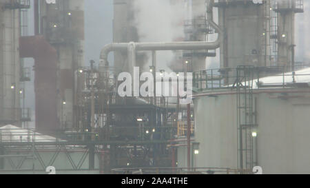 Les pluies acides, les émissions atmosphériques d'une raffinerie de pétrole. La pollution et la fumée viennent de cheminées. Le smog et la fumée qui sortait des cheminées. La pluie acide, de troubles de l'air. Banque D'Images