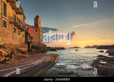 Tellaro sea village, église et en bateau au coucher du soleil. Cinq Terres, Cinque Terre, la Ligurie Italie Europe. Banque D'Images