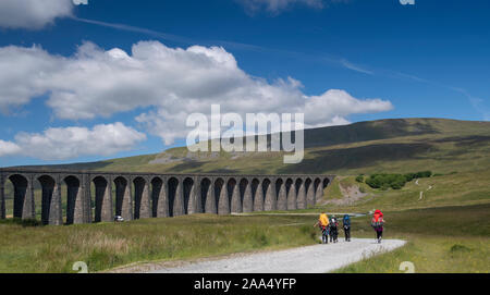 Les Marcheurs la position le long de la voie vers le viaduc de Ribblehead et Whernside, l'un des trois pics dans le Yorkshire Dales National Park, Royaume-Uni. Banque D'Images