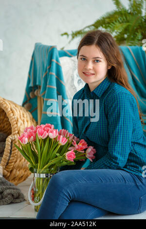 Séance photo - friendly family. Portrait d'une jeune fille de printemps avec des tulipes roses. Banque D'Images