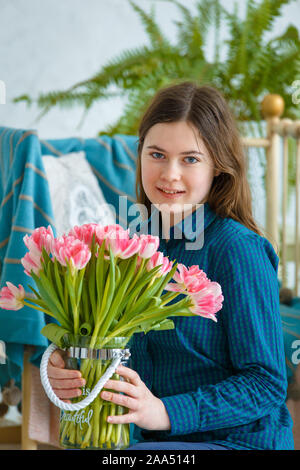 Séance photo - friendly family. Portrait d'une jeune fille de printemps avec des tulipes roses. Banque D'Images