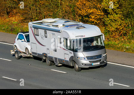 Blanc 2014 Sprinter Rapido, petite voiture remorquage freiné sur un cadre ; UK le trafic de véhicules, transports, véhicules modernes, voitures, automobile sud-nord sur la voie 3 de l'autoroute autoroute M61. Banque D'Images