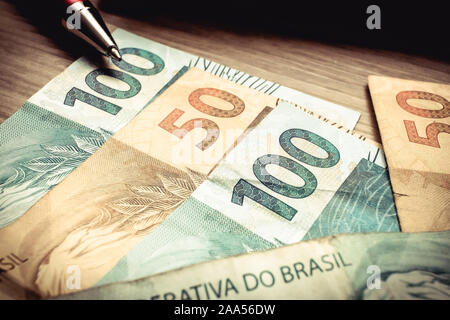 Monnaie brésilienne. De l'argent sur la table en bois dans cent cinquante reais billets. Banque D'Images