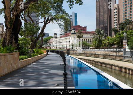 Un chemin le long d'un canal avec un pont, près d'une mosquée et de vieux bâtiments coloniaux à Kuala Lumpur Banque D'Images