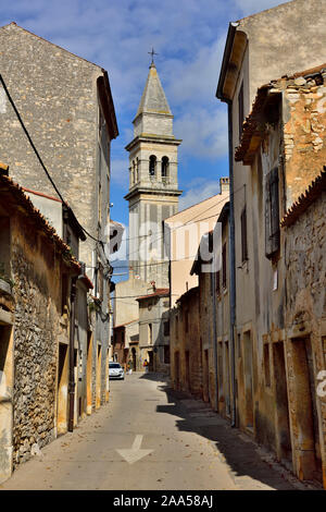 Petite rue (ul) dans la petite ville de Vodnjan avec l'église de Saint Blaze Bell Tower à distance, Istrie, Croatie Banque D'Images