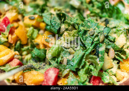 Salade de légumes verts hachés gros plan macro avec de la laitue romaine et végétalien tomates rouges, poivrons jaunes, et la levure alimentaire avec pumpki Banque D'Images