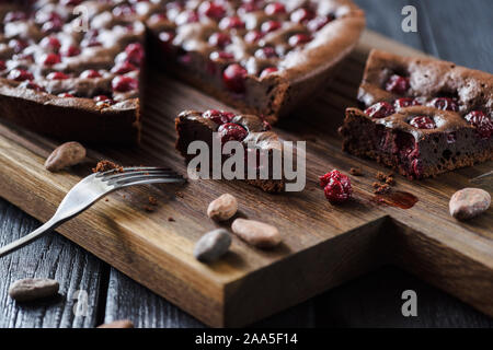 Dessert au chocolat délicieux. Des brownies aux cerises et les fèves de cacao sur oak board low angle view Banque D'Images
