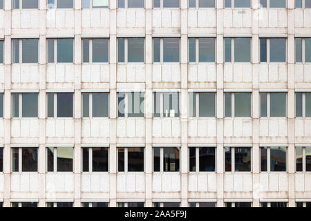 Sa façade grise d'un bâtiment de bureaux de plusieurs étages avec un motif symétrique de windows. Banque D'Images