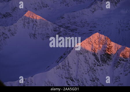 Coucher du soleil photo aérienne d'une paire de sommets à distance dans les montagnes Chugach en hiver, Alaska Banque D'Images